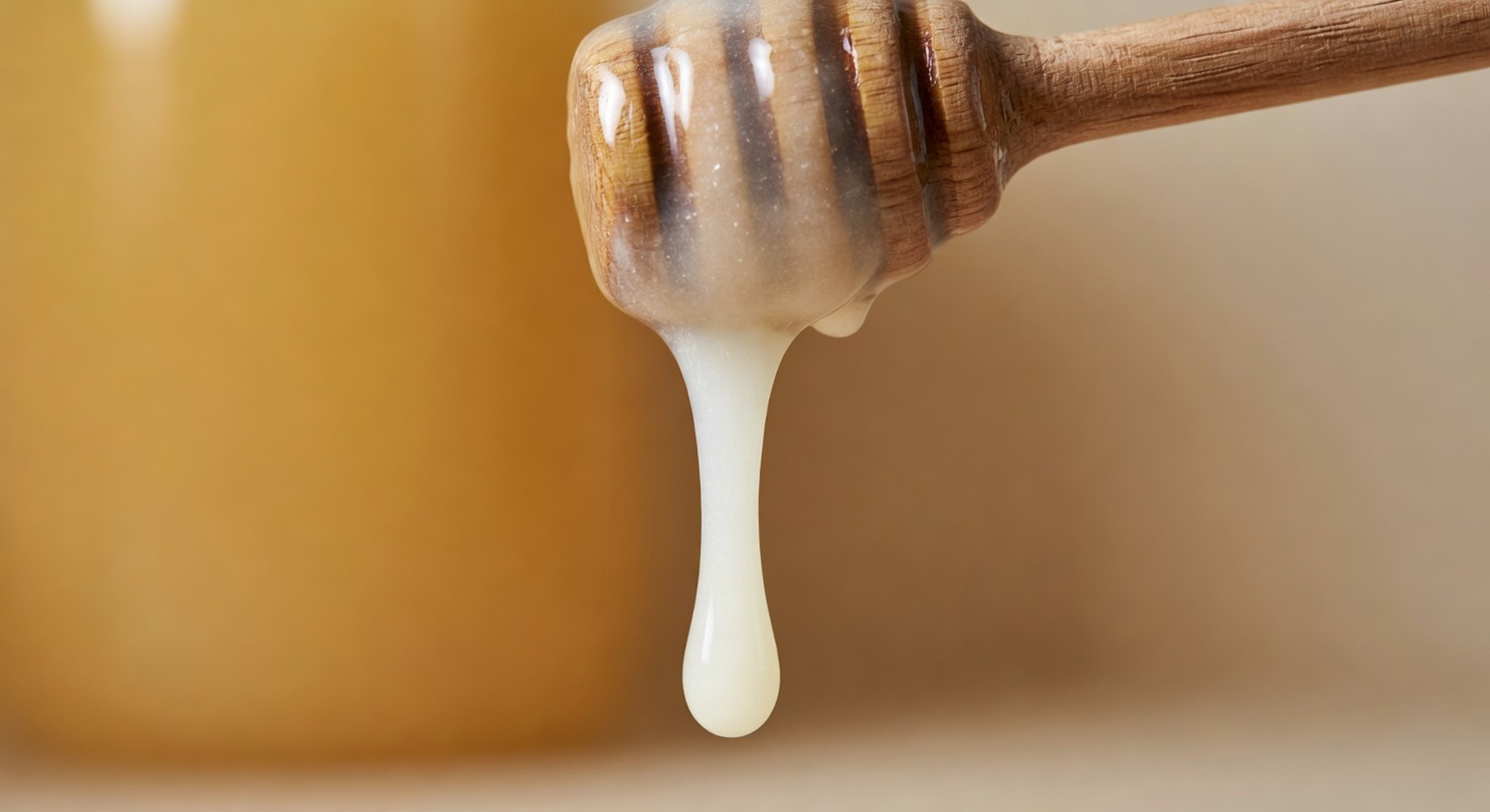 Cremig-weißer Rapshonig auf Holzlöffel – mild-süßes Aroma sichtbar